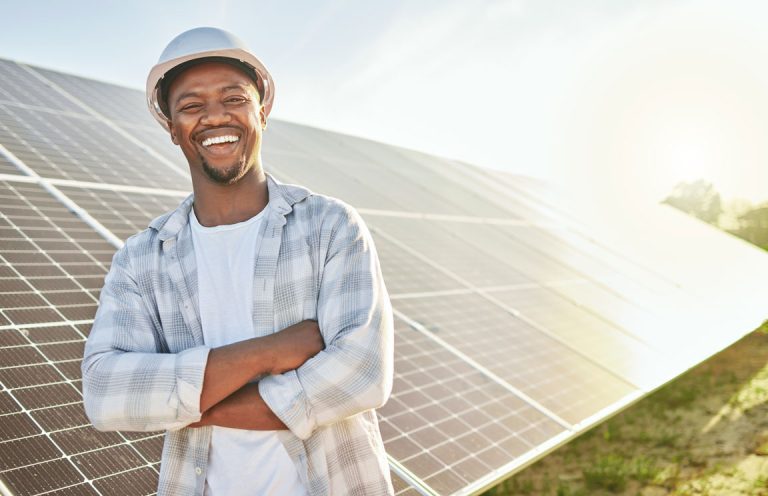 smiling man in front of solar panels